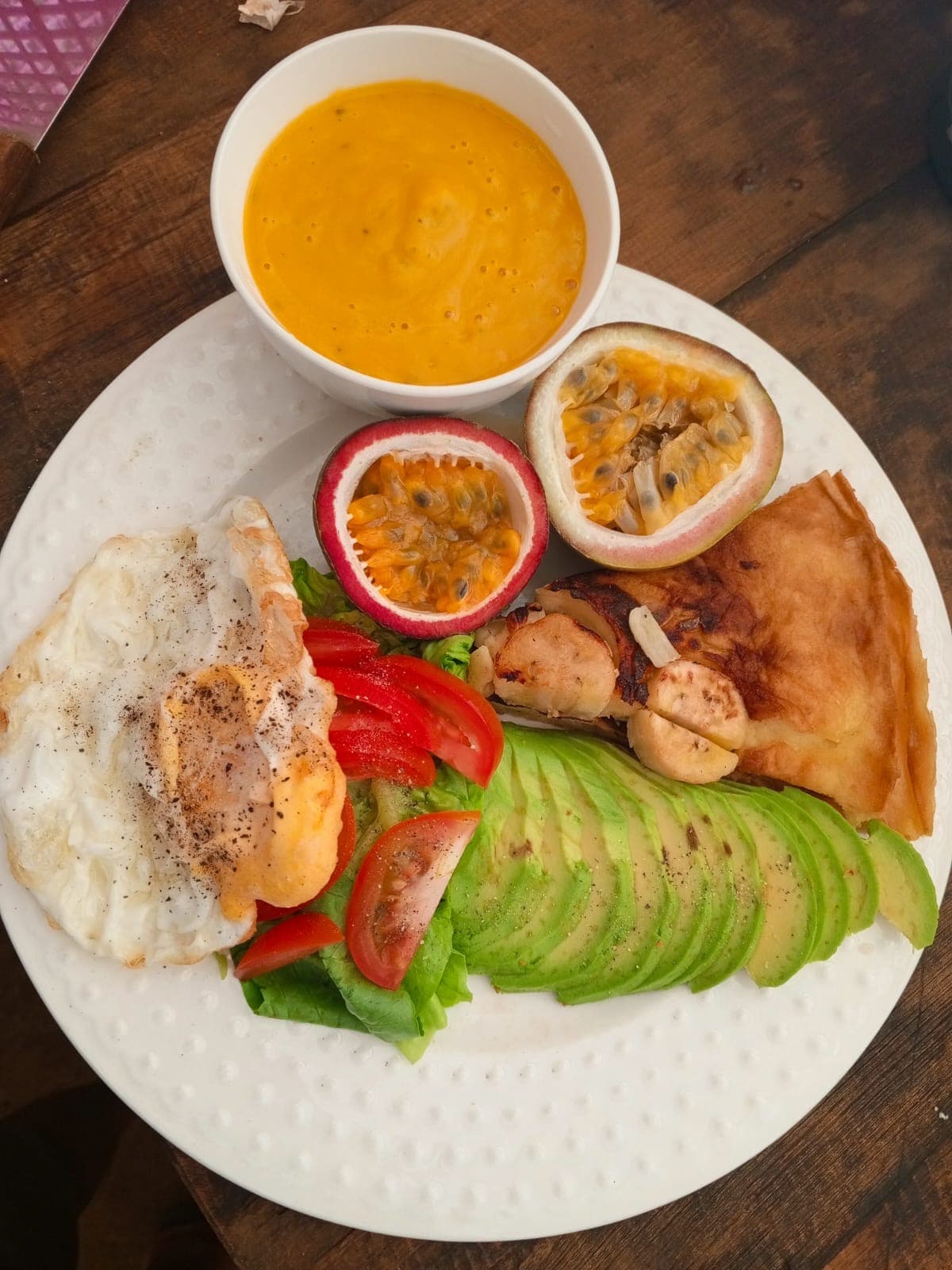 Traditional farm breakfast featuring fresh bread, passion fruit jam, and seasonal vegetables from the garden